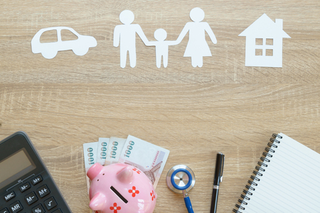 Top view of insurance concept with family, car, house paper, stethoscope,piggy bank, calculator and moneyの写真素材