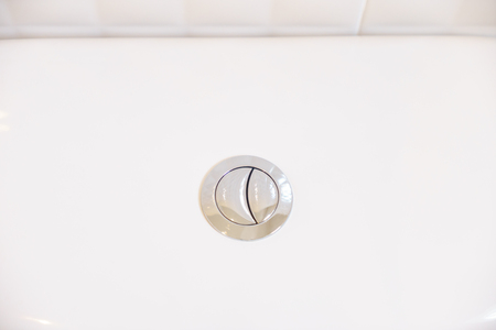 Close up of flush toilet button.