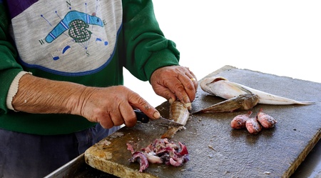 fisherman gutting and preparing fish Descrの写真素材