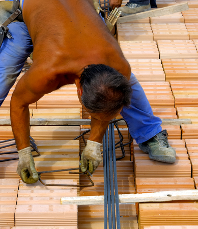 worker in workwear making reinforcement metal framework for concrete pouring.の写真素材