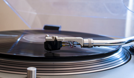 Close up of a turntable needle head playing music from an lp.  (shallow focus).の写真素材