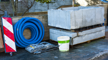 Pit precast concrete block and roll corrugated conduit deposited on a sidewalkの写真素材