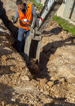 Worker checks it performed digging with an excavatorの写真素材