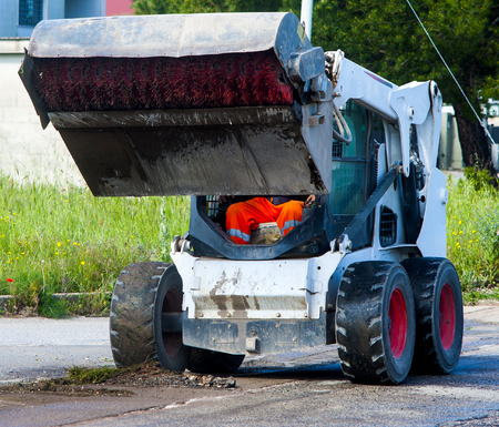 Sweeper attachments mini excavator. The sweeper sweeps, collects and dumps dirt and debris.