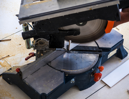 Closeup view wooden board electric circular saw. Focus is on the toolsの写真素材