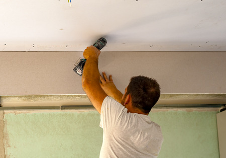 Fixing plasterboard sheets to the frame.の写真素材