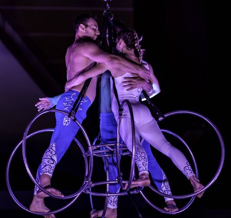 Bitonto, Italy - May 28, 2017: Acrobats perform a trick on slings suspended in the void and secured with harnesses on a festive evening in the main square of Bitonto, Pugliaのeditorial素材