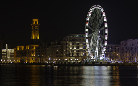 Panoramic Night view of Illuminated giant Ferris wheel on the waterfront of Bari. Apulia, Italy.の写真素材
