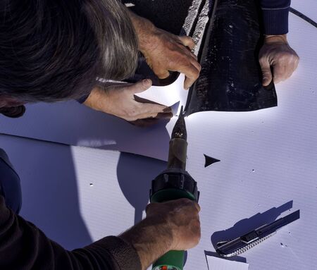 Worker cut and weld heat PVC sheet with a scissorsの写真素材