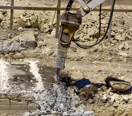 Excavator with demolition hammer in a construction siteの写真素材