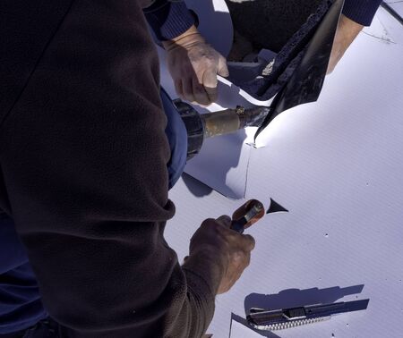 Worker cut and weld heat PVC sheet with a scissorsの写真素材