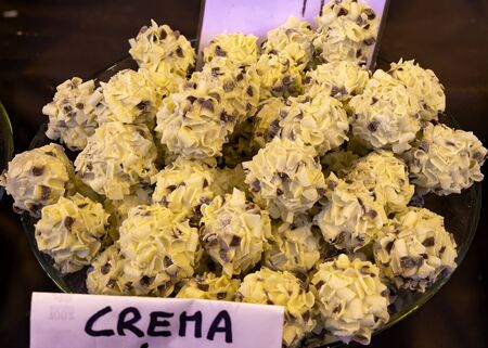 chocolate and cream truffles, beautifully arranged on a chocolate maker's counter during a fair. The word "CREMA" is indicated on the plate. Selective focusの写真素材