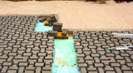 Heap of interlocking paving stones; Material for paving works on sheet of nonwoven