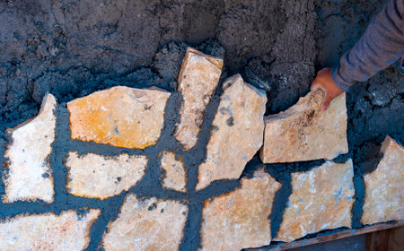 Construction site - workers wall cladding stoneの写真素材