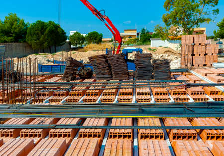 Crane settled steel bars construction materials, in a construction site.の写真素材