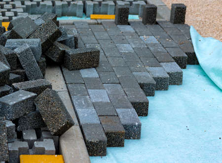 Heap of interlocking paving stones; Material for paving works on sheet of nonwoven