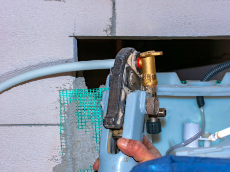 Worker with multilayer pipe presser is assembling the metal bushings of the fittingsの写真素材