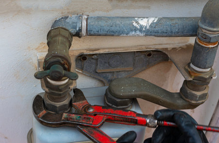 Worker with a caliper disassembles a fitting between the pipe and gas meter. Selective focusの写真素材