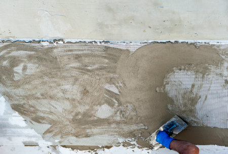 Hand using trowel on fresh concrete in construction siteの写真素材