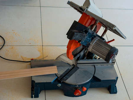 Circular saw and timber strip on table in carpenter's workshop