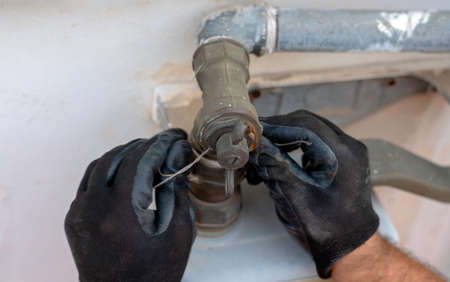 Worker removes the seals to the fitting between the pipe and gas meter. Selective focusの写真素材
