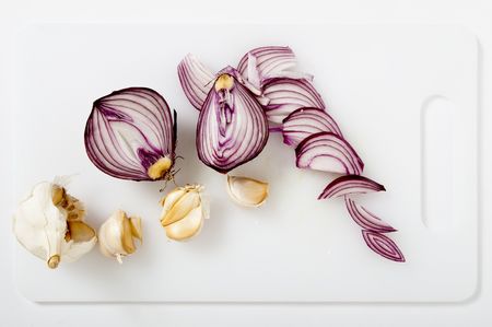 onions and garlic on cutting board whiteの写真素材