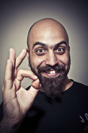 happy man who says ok with his hand on dark backgroundの写真素材