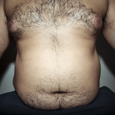 belly fat and hairy man with handsの写真素材