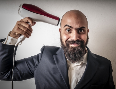 man bearded and jacket with hairdraier and funny expressions on white backgroundの写真素材