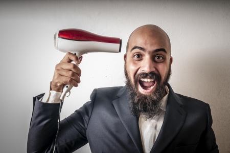 man bearded and jacket with hairdraier and funny expressions on white backgroundの写真素材