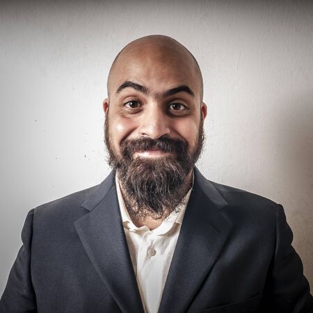 elegant bearded man with jacket and funny expressions on white backgroundの写真素材