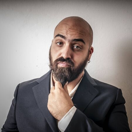 elegant bearded man with jacket and funny expressions on white backgroundの写真素材