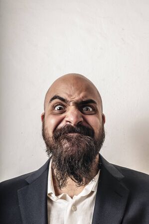 elegant bearded man with jacket and funny expressions on white backgroundの写真素材