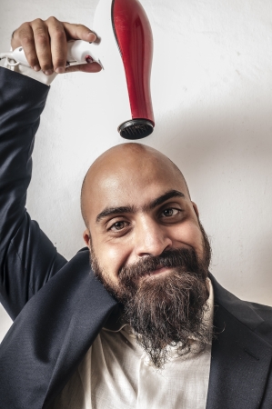 man bearded and jacket with hairdraier and funny expressions on white backgroundの写真素材
