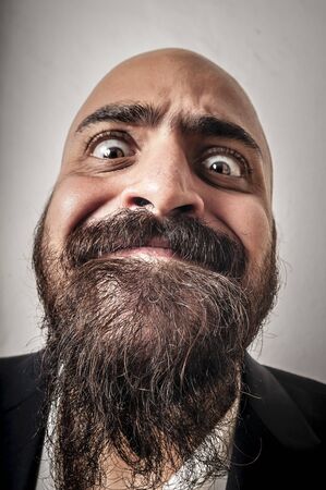 elegant bearded man with jacket and funny expressions on white backgroundの写真素材
