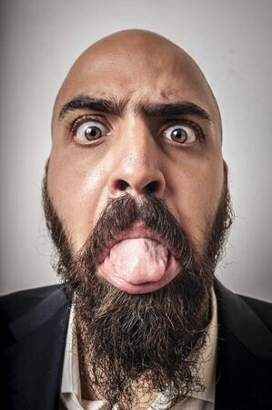 elegant bearded man with jacket and funny expressions on white backgroundの写真素材