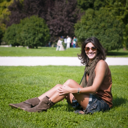 beautiful girl with scarf and sunglasses on the lawn in autumnの写真素材