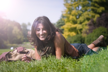 beautiful girl with scarf on the lawn in autumnの写真素材