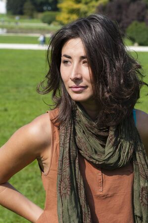beautiful girl with scarf on the lawn in autumnの写真素材