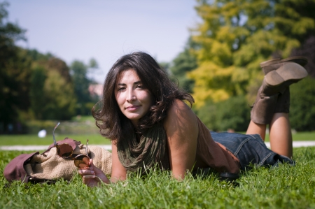 beautiful girl with scarf on the lawn in autumnの写真素材