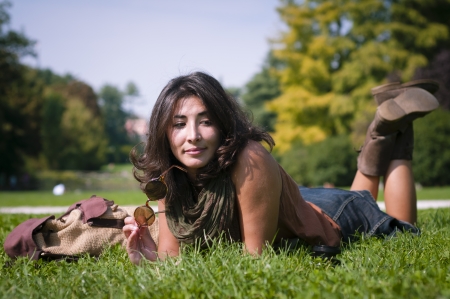 beautiful girl with scarf on the lawn in autumnの写真素材