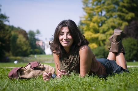 beautiful girl with scarf on the lawn in autumnの写真素材