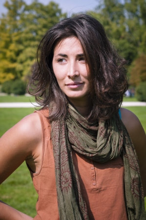 beautiful girl with scarf on the lawn in autumnの写真素材