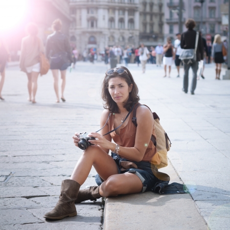 beautiful girl with scarf and camera on the lawn in autumnの写真素材
