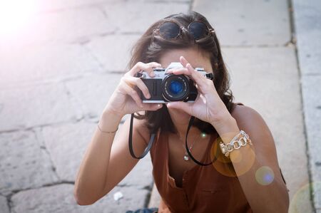 beautiful girl with scarf and camera on the lawn in autumnの写真素材