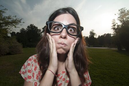 girl with big glasses and strange expressions at the parkの写真素材
