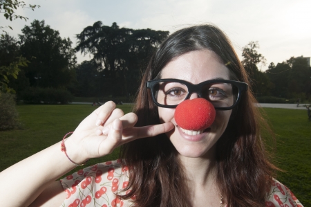 clown girl with red nose at the park in milanの写真素材