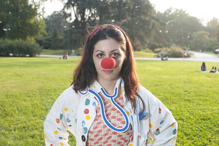 clown girl with red nose at the park in milanの写真素材