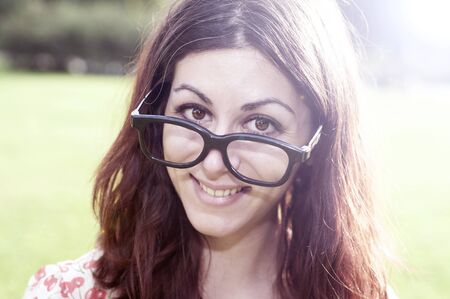 smiling girl with big glasses and strange expressions at the parkの写真素材