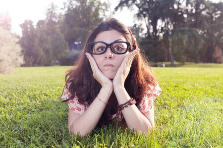 girl with big glasses and strange expressions at the parkの写真素材